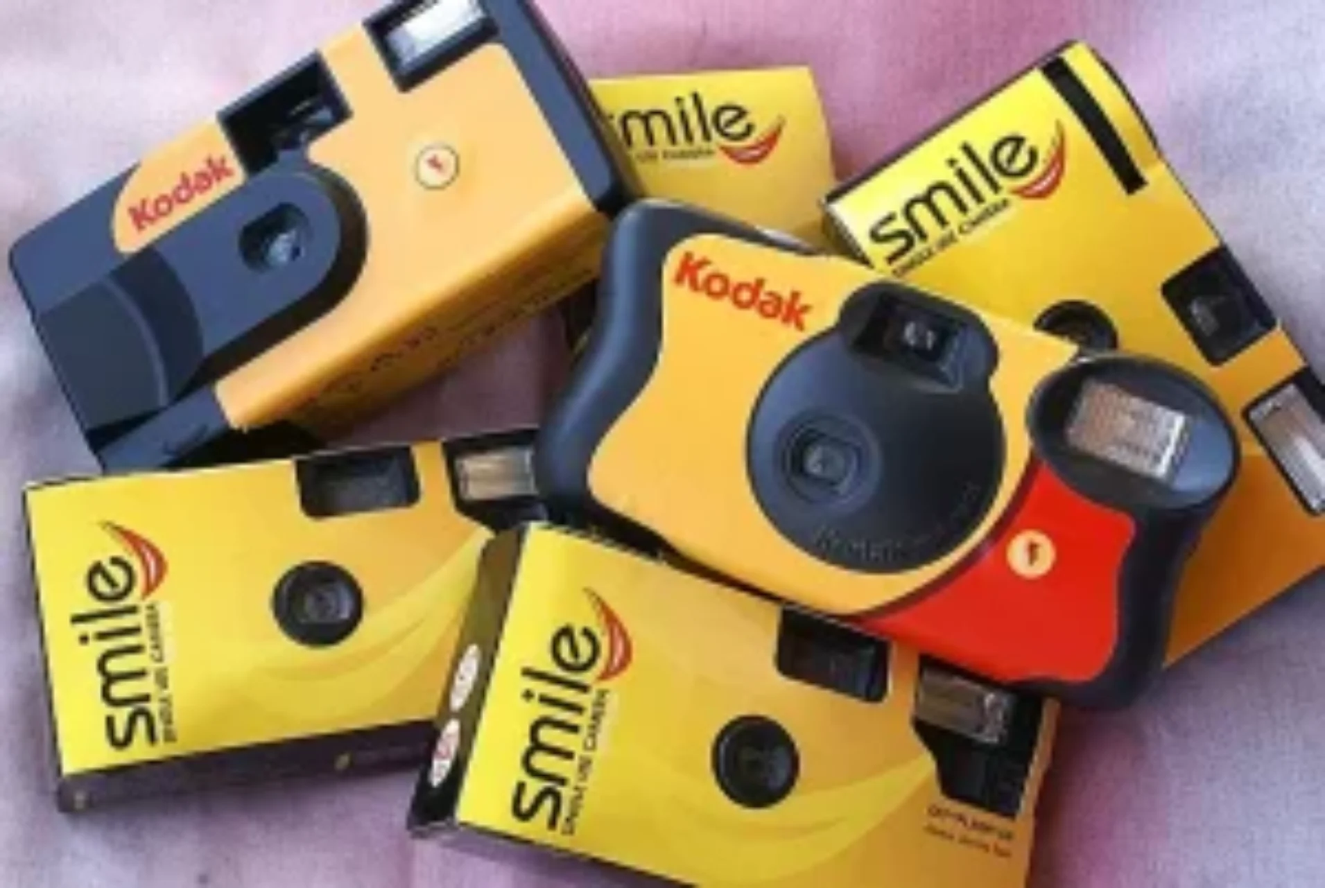 A variety of Kodak disposable cameras arranged on a pink surface. #disposable camera film