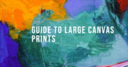 Close-up of a colorful abstract painting with bold strokes of orange, yellow, green, and blue, with the text ‘Guide to Large Canvas Prints’ overlaid in white font.